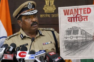 Indian male police officer wearing tan police uniform giving speech holding up a picture of a train.