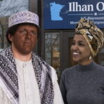 Investigator journalist James O'Keefe dressed as a Somali man standing in front of Ilhan Omar's office as the Somali woman Ilhan stares at him.