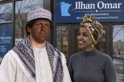 Investigator journalist James O'Keefe dressed as a Somali man standing in front of Ilhan Omar's office as the Somali woman Ilhan stares at him.