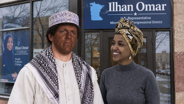 Investigator journalist James O'Keefe dressed as a Somali man standing in front of Ilhan Omar's office as the Somali woman Ilhan stares at him.
