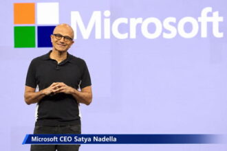 Bald male Indian Microsoft CEO on stage giving a speech.
