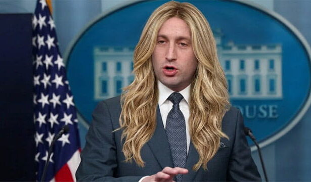 Trump Chief of Staff Stephen Miller wearing a long blonde wig speaking behind a White House Press Secretary podium.