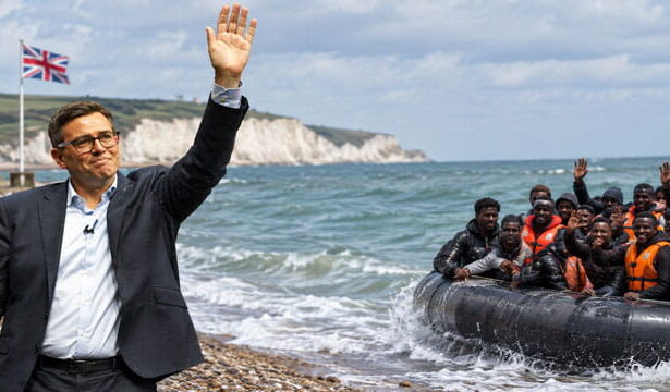 UK Prime Minister Andy Burnham waving to a group of African migrants on a boat.